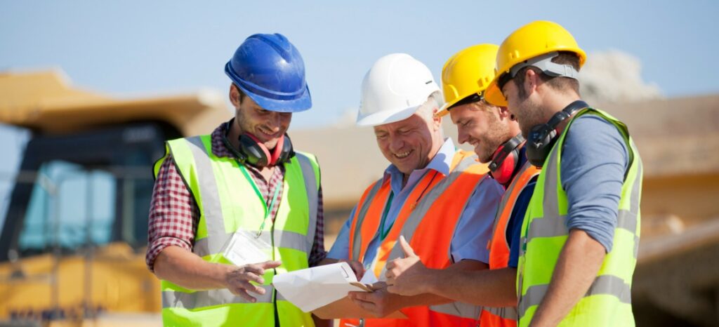 workers and businessman looking over project details
