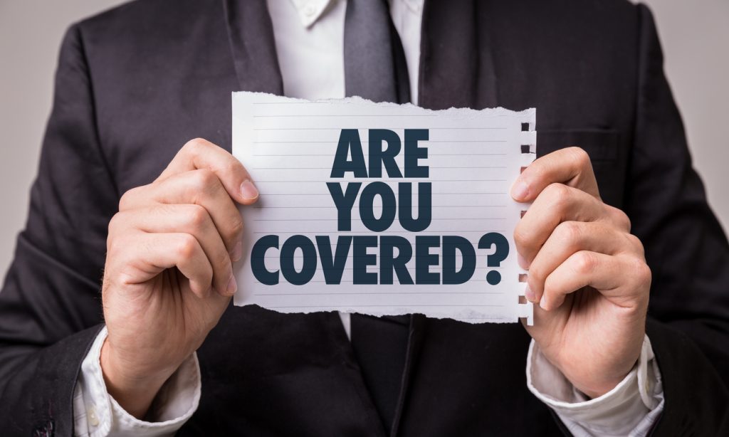 man in suit holding paper with "are you covered?"