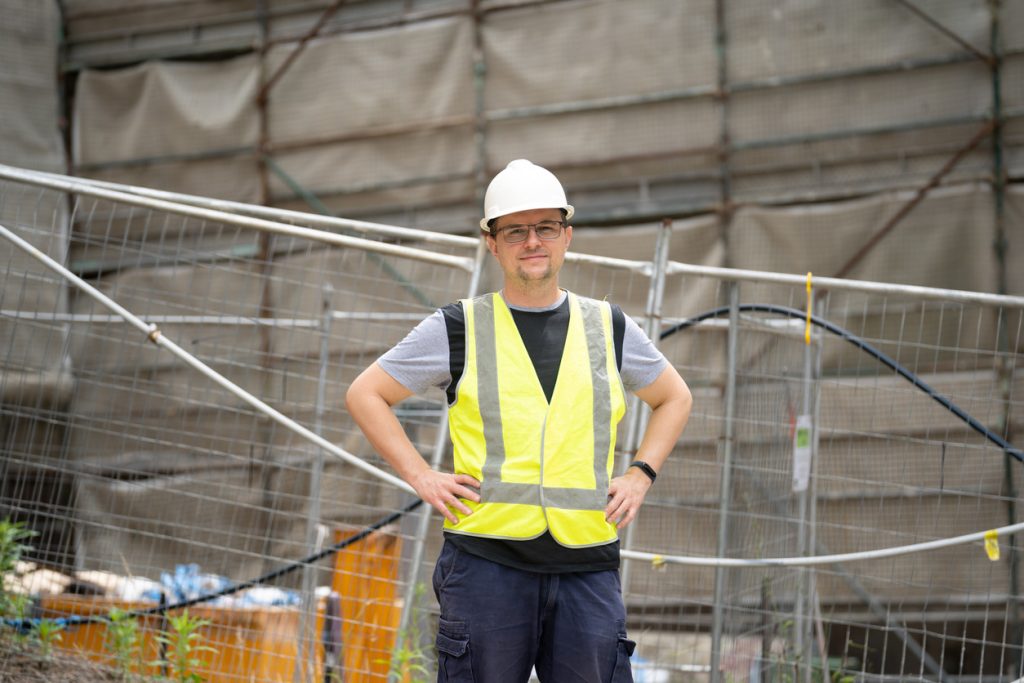 city tradie standing in front of construction site