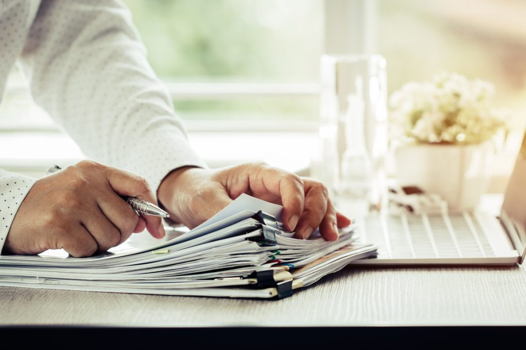 man flipping through a stack of paperwork